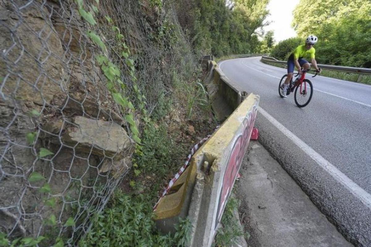 Un ciclista a la carretera perquè no pot passar pel voral.