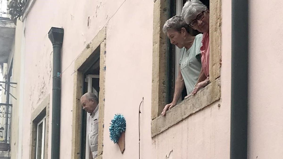 Turistas asomados a la ventanas en la Alfama.