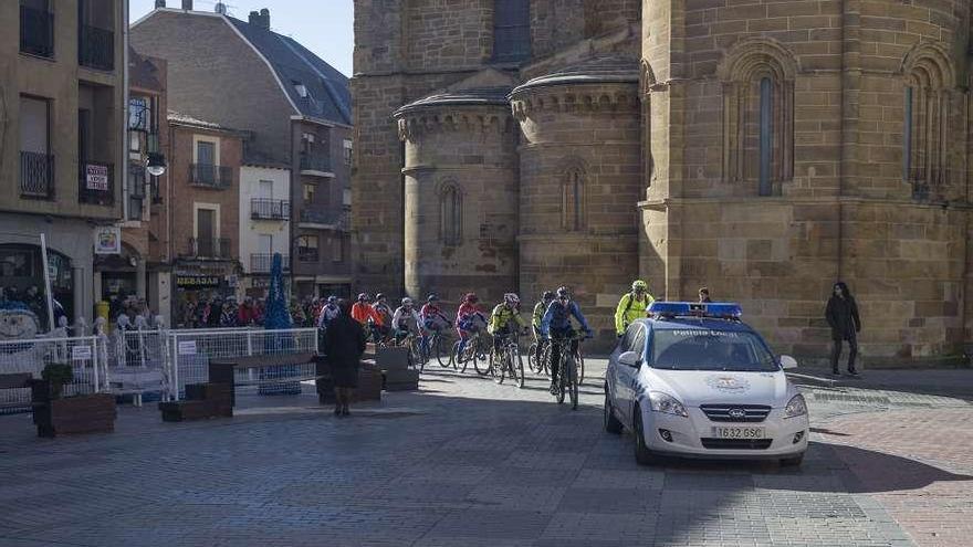 Un vehículo policial abre la comitiva de una marcha ciclista un domingo de enero.