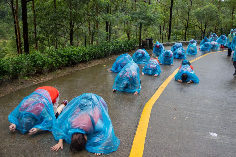 La gente se arrodilla mientras oran en la montaña de Guanyin en un día lluvioso en Dongguan, provincia de Guangdong, China