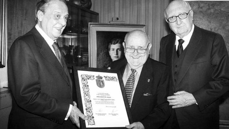 Sabino Fernández Campo, a la izquierda, recibe la distinción de manos de Cosme Sordo, en presencia de Aurelio Ménendez.