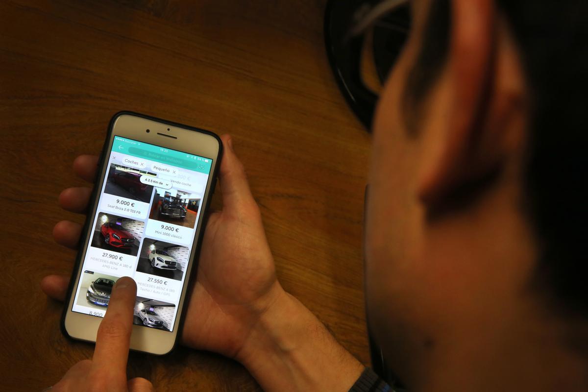 Una persona mira anuncios de coches por Wallapop
