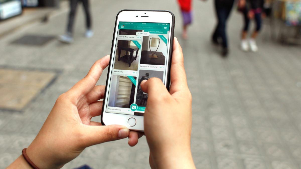 Una persona mira las ventas de Wallapop en la calle