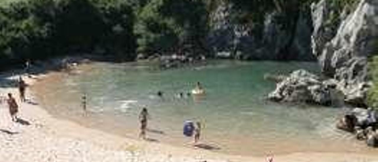 Algunos turistas en la playa interior de Gulpiyuri.