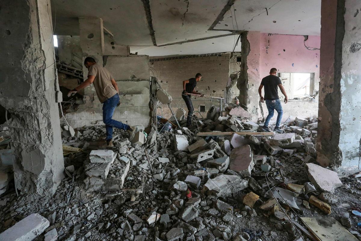 La gente comprueba los daños dentro de un edificio en la ciudad ocupada de Jenin, en Cisjordania, tras un ataque aéreo israelí