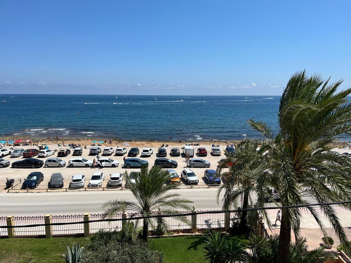 Los bañistas tienen que colarse entre los estrechos huecos que dejan los coches