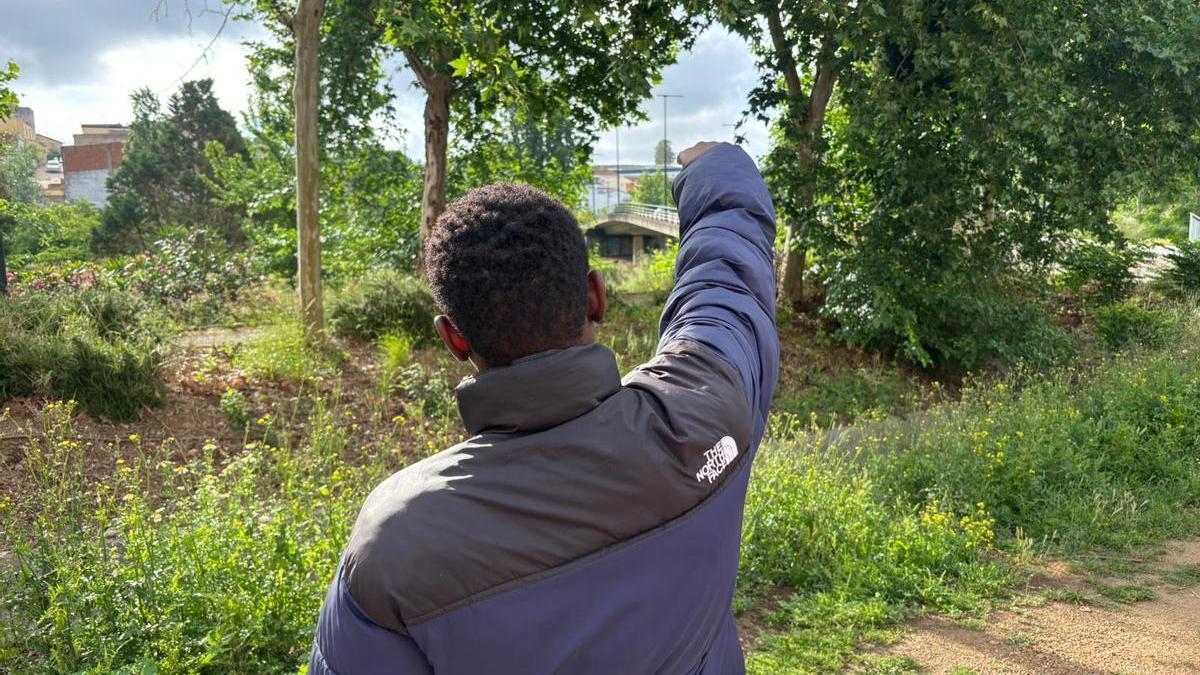 Uno de los 17 migrantes de Mali señala el puente bajo el que duermen desde que fueron desalojados de la estación de autobuses de Badajoz.