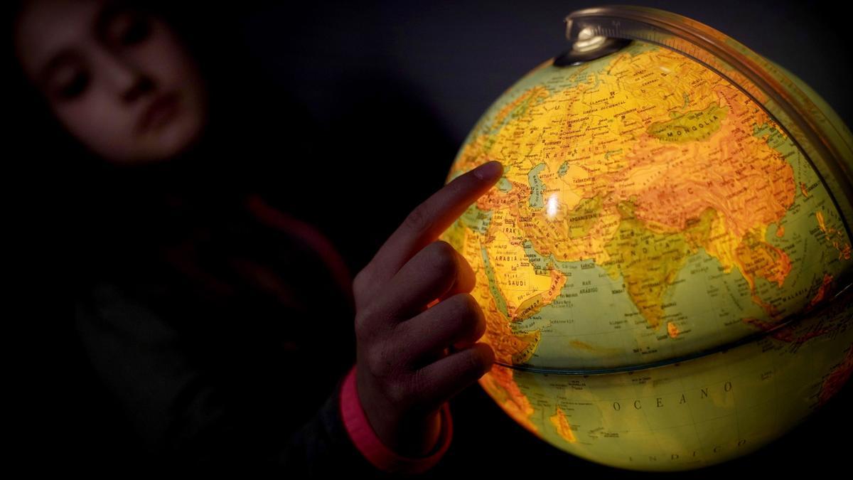 Una niña señala Ucrania en un globo terráqueo. FOTO JOSÉ LUIS ROCA