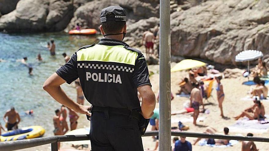 Un agent de la Policia Local vigila que es mantinguin les distàncies de seguretat a la platja de Tamariu