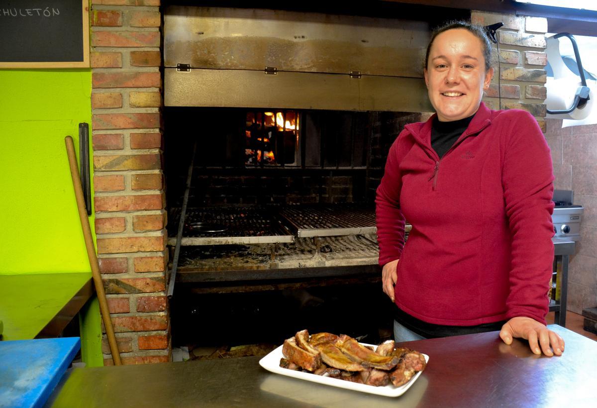 Cristina Remis, frente a la parrilla en la que trabaja, en su bar La Tilar en Meré (Llanes).