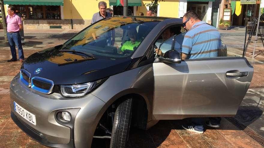 El alcalde de Cangas de Onís, José Manuel González, prueba un coche eléctrico en la plaza Camila Beceña en compañía del presidente de la Federación de Automovilismo del Principado, Carlos Márquez.