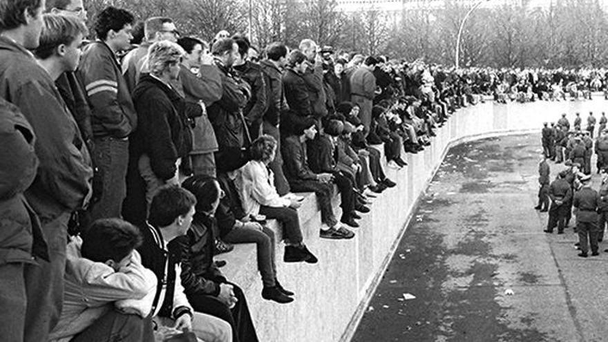 Imagen que muestra a centenares de jóvenes sobre el Muro de Berlín el día antes de ser derribado. | lp / dlp
