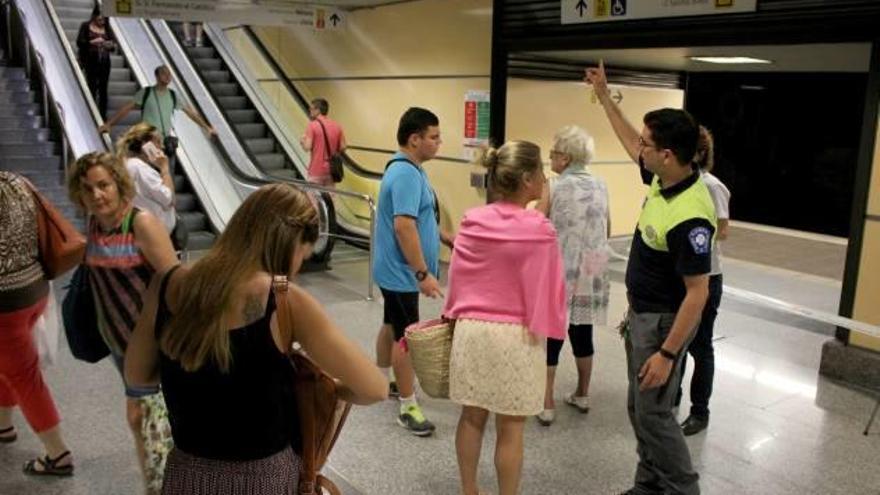 Un agente de seguridad da indicaciones a una viajera en la estación de Àngel Guimerà.