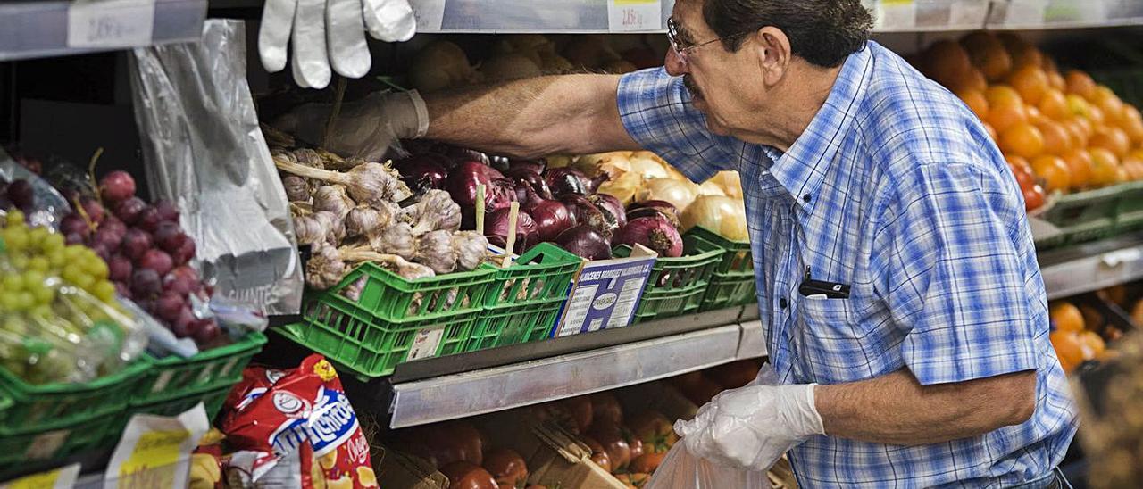Un hombre hace la compra de frutas, verduras y hortalizas en un supermercado de las Islas.