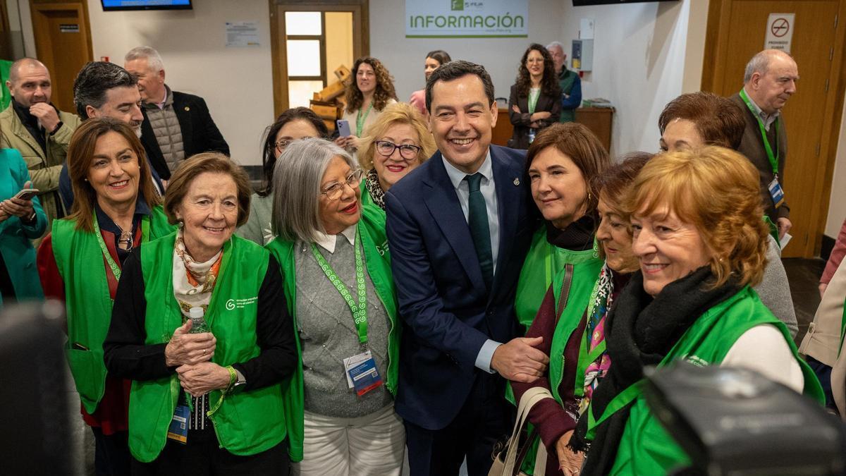El presidente de la Junta de Andalucía, Juanma Moreno, saluda a miembros de la Asociación Española contra el Cáncer de Jaén antes de inaugurar en el VII Congreso Andaluz de Personas con Cáncer y sus Familias