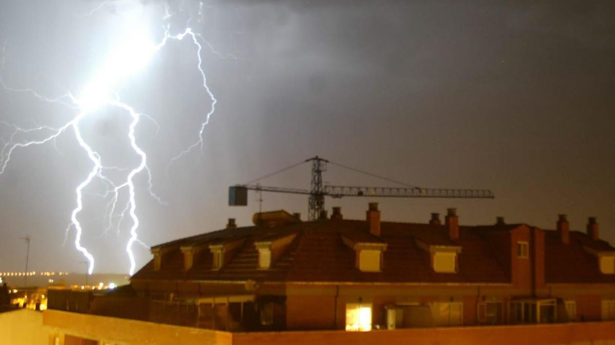 Un rayo cae cerca de una vivienda.