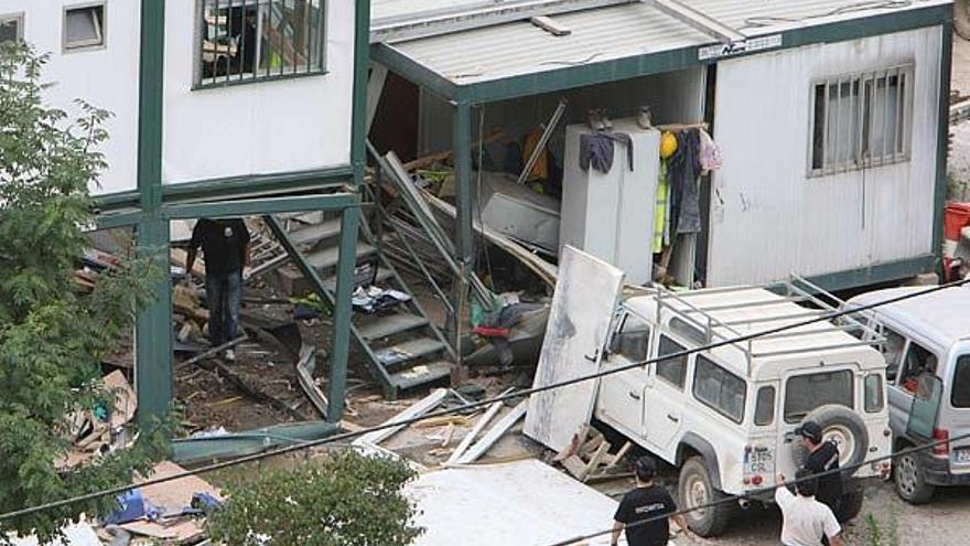 Agentes de la Ertzaintza inspeccionan una de las casetas que sufrieron daños por la explosión.