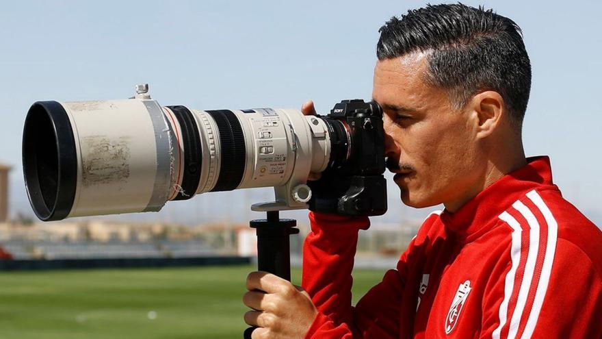 José Callejón, ayer, al término de la sesión de trabajo del Granada CF, mira por el visor de una cámara fotográfica. | | LP/DLP