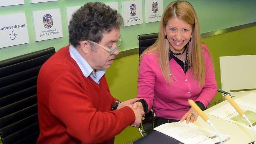 El alcalde Miguel Fernández Lores y Beatriz Rodríguez se dan la mano tras firmar el convenio.  // R. V.