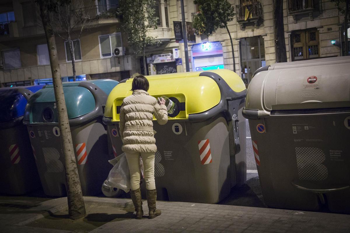 Un señora tira la basura en uno de los contenedores de la ciudad de Barcelona. Foto archivo