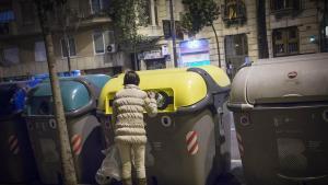 Un señora tira la basura en uno de los contenedores de la ciudad de Barcelona. Foto archivo