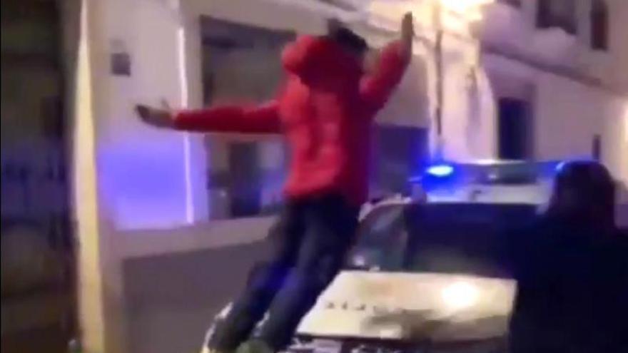 Momento en el que el joven salta sobre el capó del coche de la Policía Local de Plasencia.