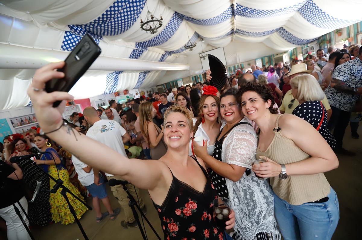 Un grupo de jóvenes se hace una 'selfie' en una caseta de la Feria de Córdoba.
