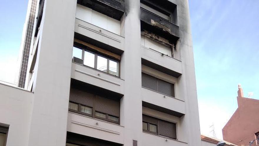 Se desprende parte de la fachada de un piso incendiado y causa daños a vehículos