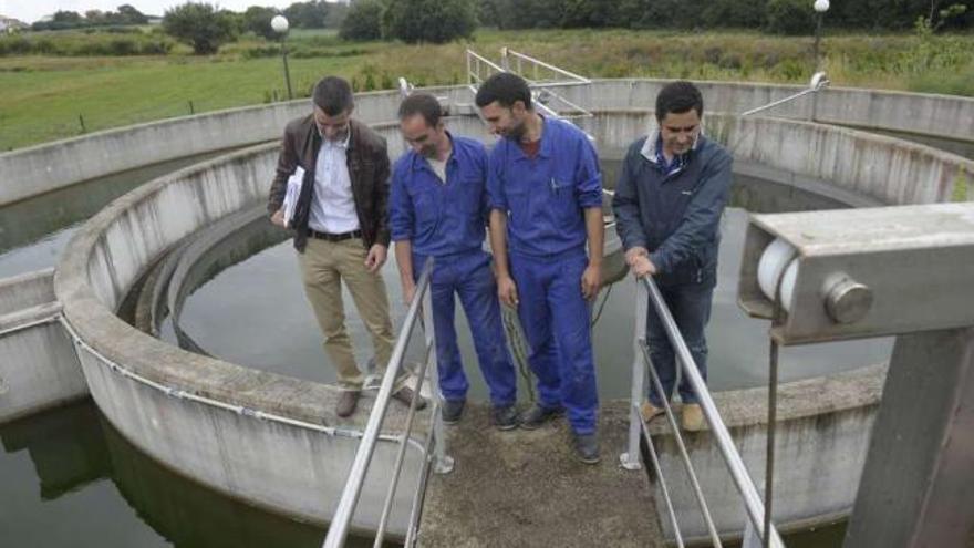 Operarios y el concejal de Obras (derecha), el pasado julio, revisan la depuradora. / víctor echave