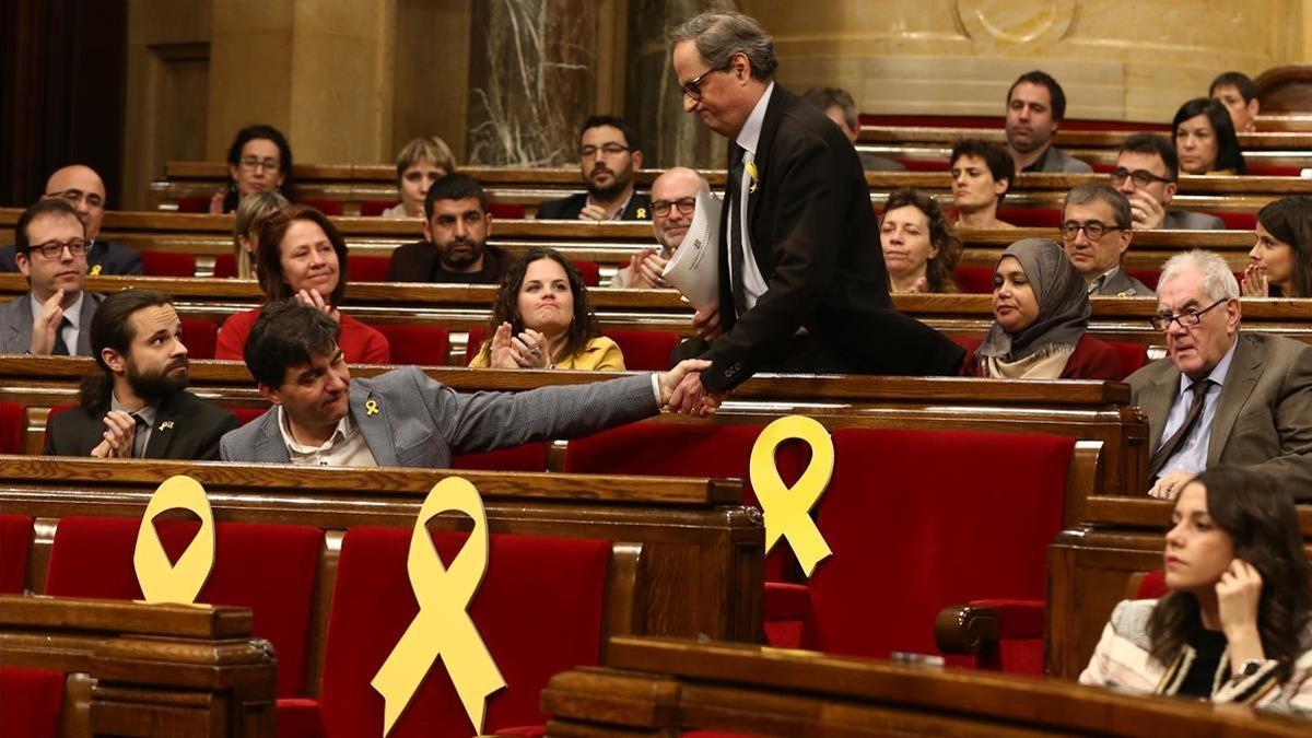 Quim Torra saluda a Sergi Sabrià durante una sesión del Parlament.