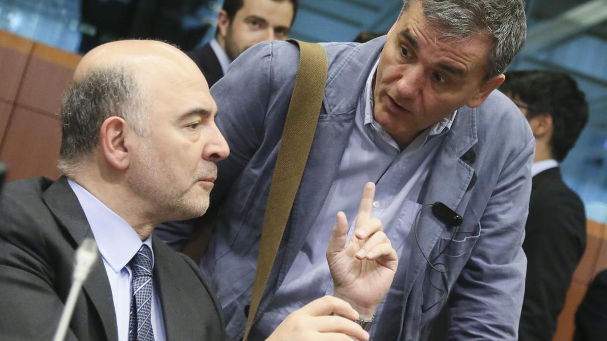 El comisario de Asuntos Económica, Pierre Moscovici (izqueirda), habla con el ministro griego de Finanzas, Euclides Tsakalotos, el martes en Bruselas.