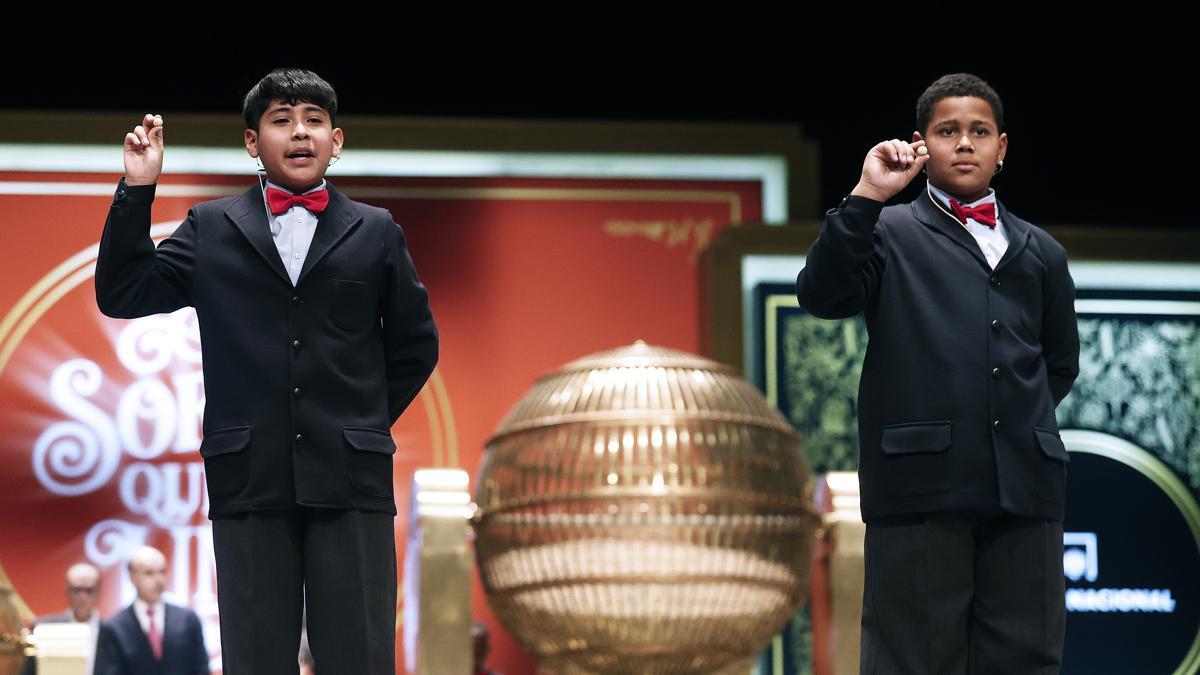 Los estudiantes de San Ildefonso Adrián Monteiro Brito (d) y Fabián Aarón Vera Chávez (i) cantan el 45.250 agraciado con el tercer premio durante el sorteo de Navidad en el Teatro Real en Madrid, este jueves. EFE/ Javier Lizón