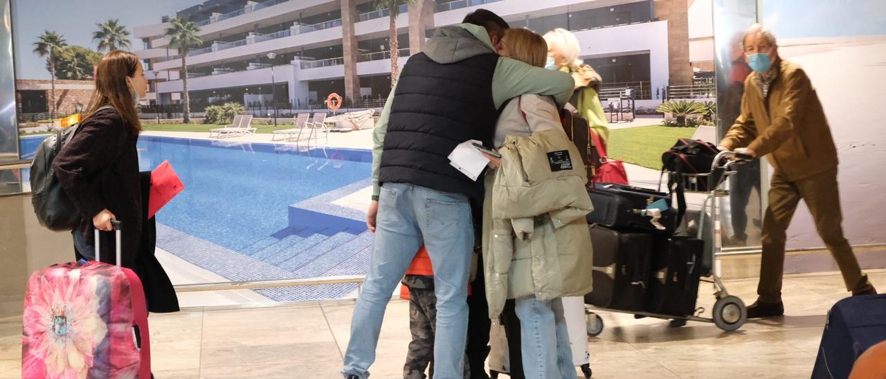 Una familia de turistas rusos se abraza en el aeropuerto de Alicante-Elche tras llegar de Moscú dos días antes del cierre del espacio aéreo