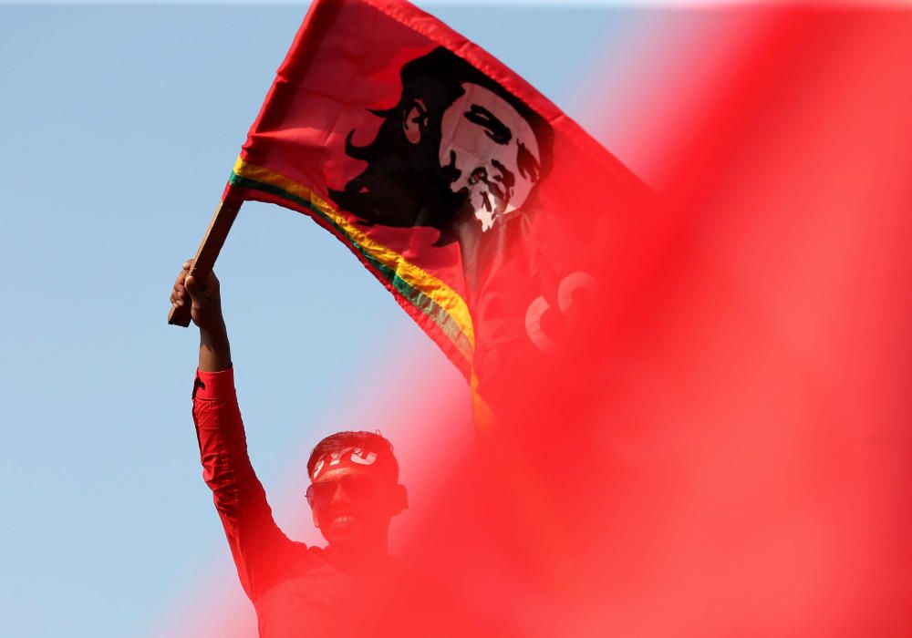 A man waves a flag with an image of Che Guevara ...