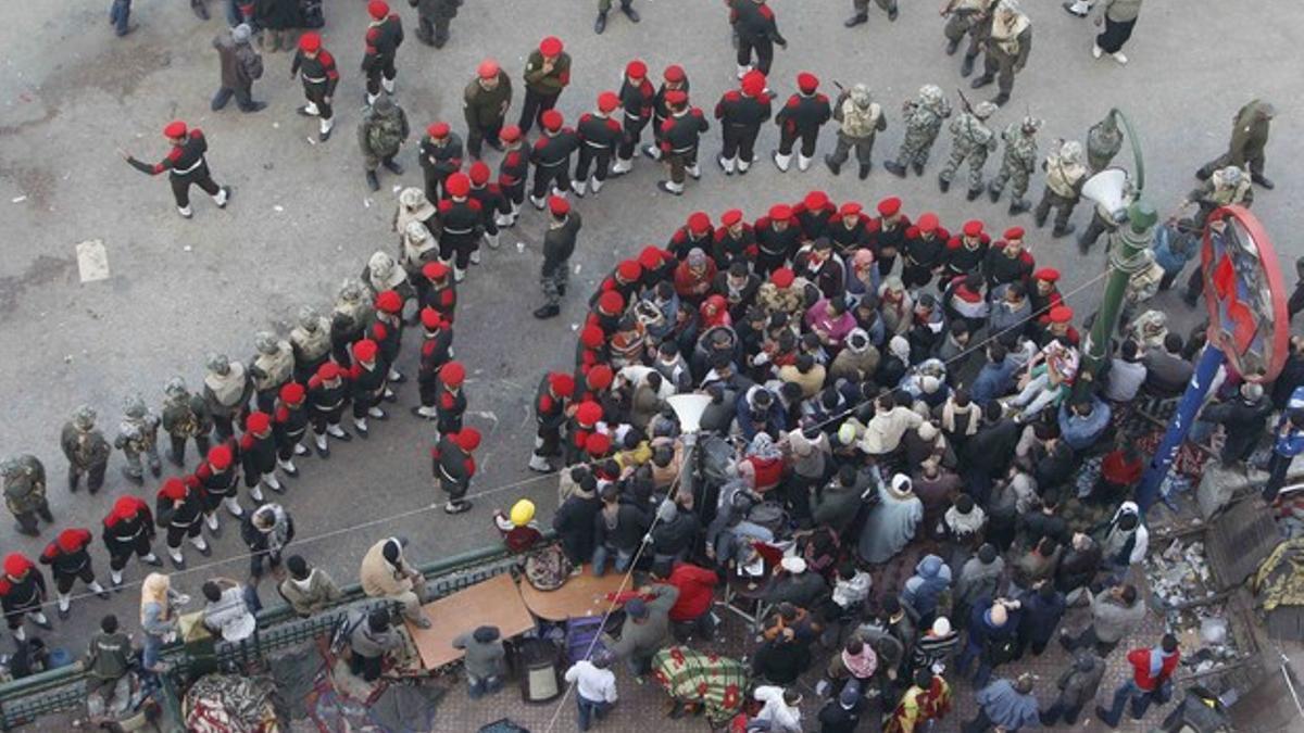 Miembros del Ejército rodean a algunos de los manifestantes que quedan en la plaza Tahrir, este lunes.