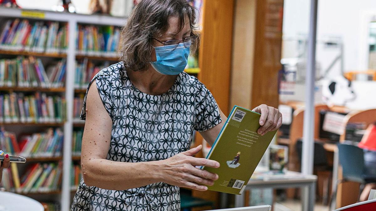 Ana Colomar, administrativa y responsable de la biblioteca municipal de Ibiza, ordenando libros en la biblioteca. 
