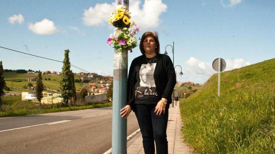 María Paz Artime, junto a la farola que recuerda el lugar del fallecimiento de su hija, cuyo rostro lleva fotografiado en la camiseta.