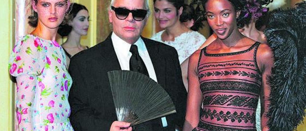 Karl Lagerfeld, entre las modelos Stella Tennant y Naomi Campbel, tras un desfile en París en 1997. Junto a estas líneas, un boceto del modisto para la colección de Fendi de 2010.  |  // L.O.