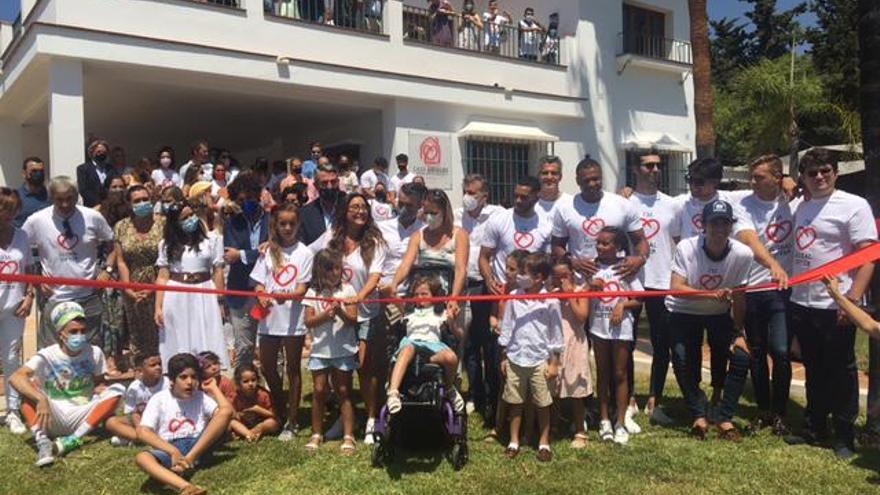 Responsables del proyecto, representantes de instituciones y menores, ayer, en el corte de la cinta de la inauguración del local.