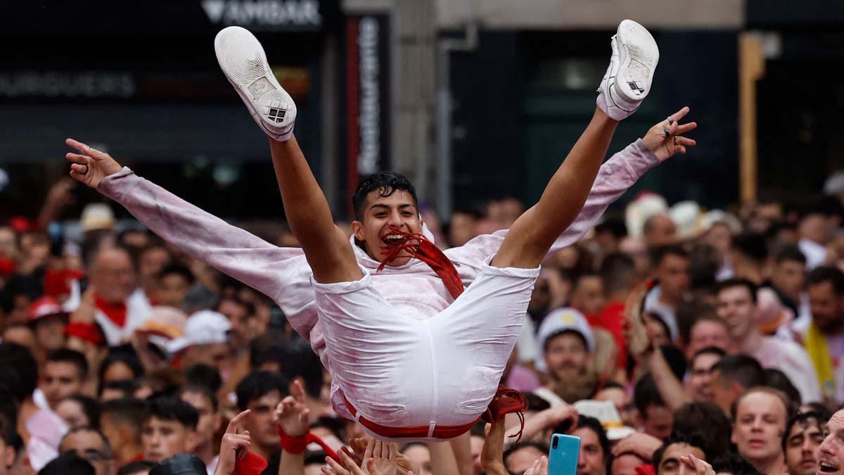 Un juerguista es lanzado al aire por otros durante la inauguración del festival de San Fermín en Pamplona.