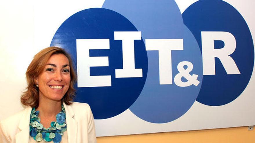 Ana Fernández posando junto al logo de su empresa, EIT&amp;R (European Institute for Teaching &amp; Research).