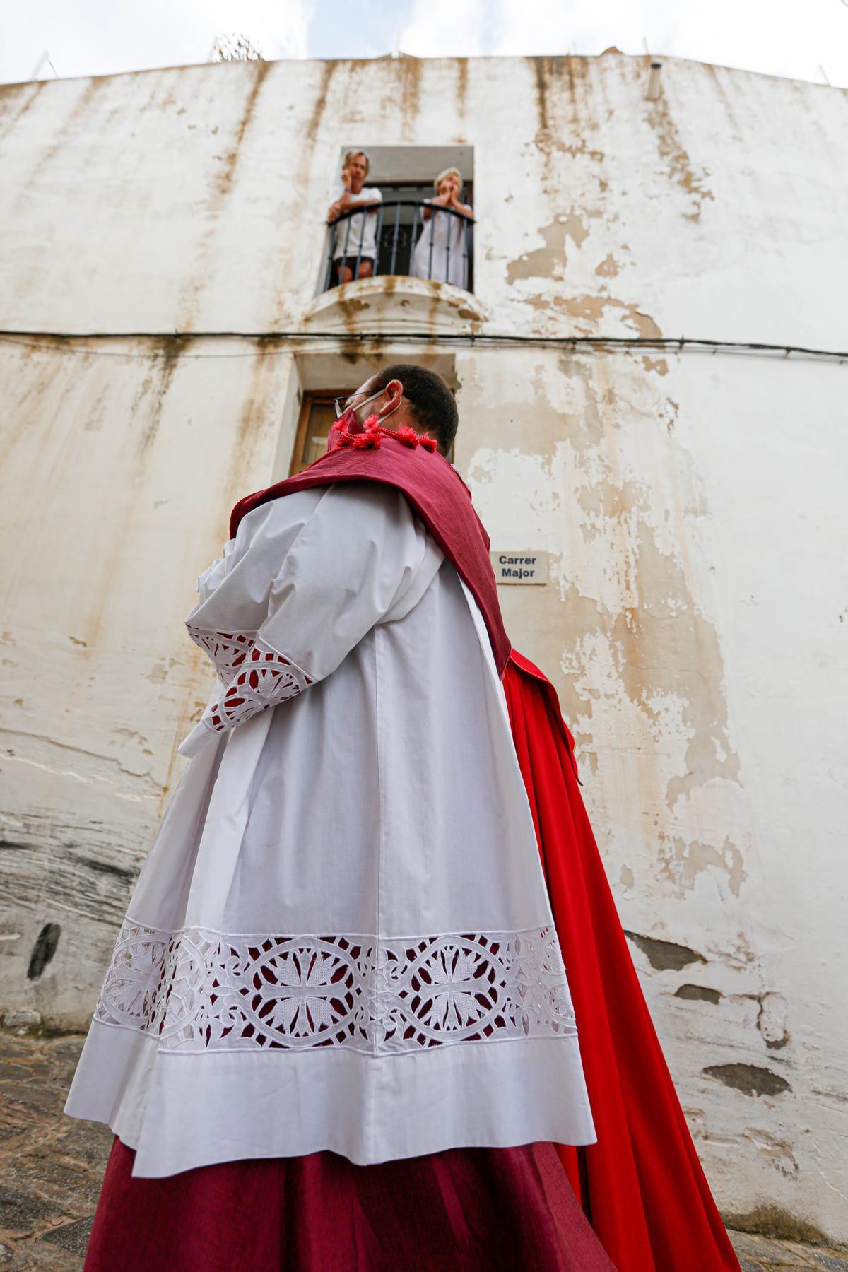 Dos personas onservan la procesión desde una ventana