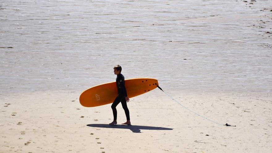 Surfistas en la playa de Riazor, en A Coruña, despiden los últimos coletazos del verano