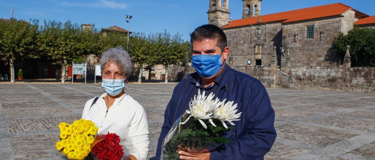 Una vendedora de flores y Charlín, durante la presentación de ayer en la plaza de Fefiñáns