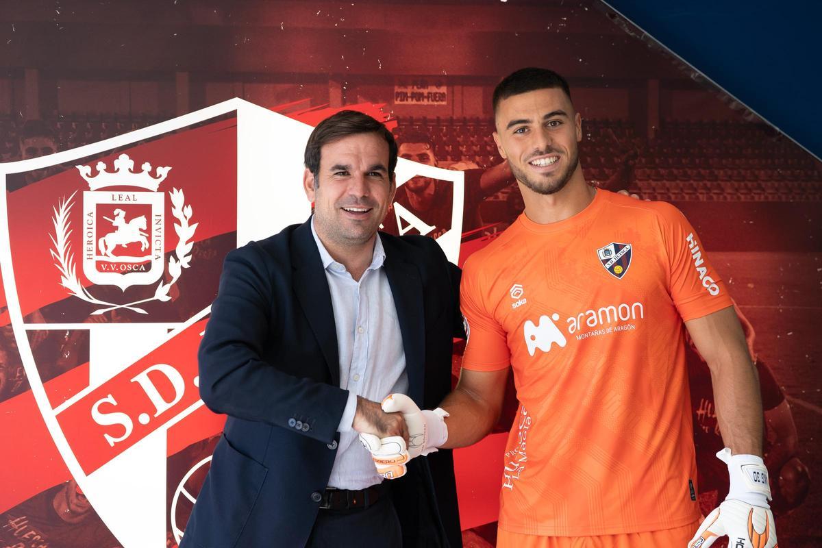 Álvaro Killane estrecha la mano con el director deportivo de la SD Huesca, Javier Sanz, en su presentación.