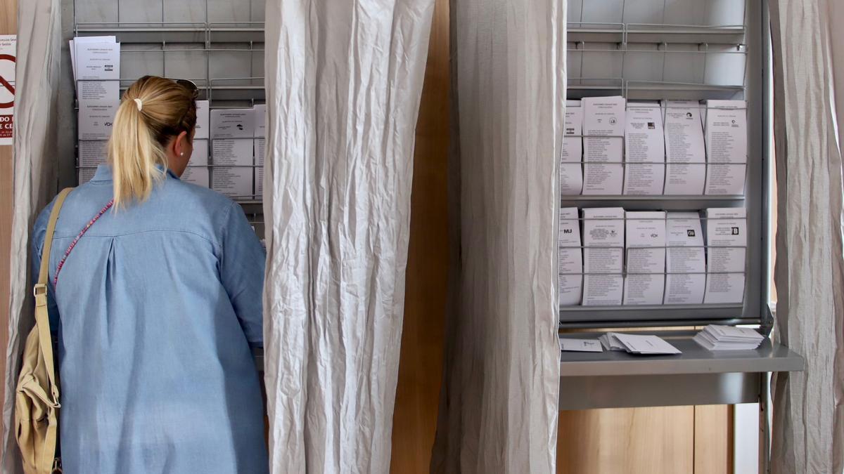 Una mujer elige su papeleta electoral en un colegio electoral de Córdoba, este domingo.