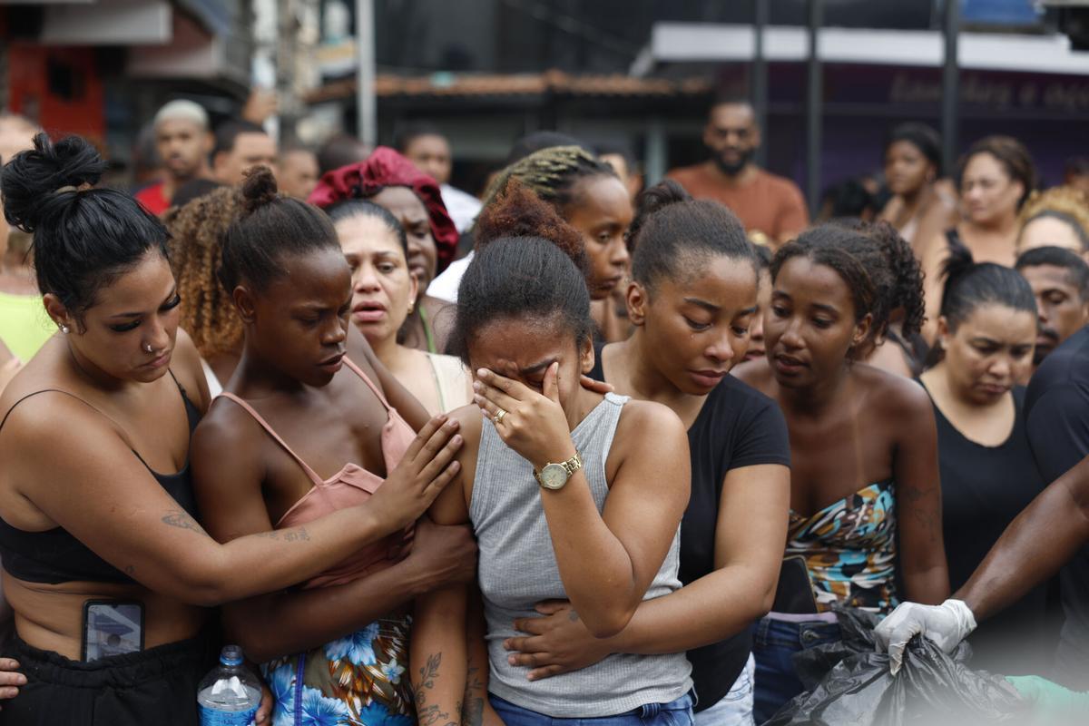 Personas lloran en una calle donde se encuentran cuerpos sin vida este miércoles, en Río de Janeiro (Brasil).EFE/ Antonio Lacerda. ATENCIÓN EDITORES: CONTENIDO GRÁFICO EXPLICITO