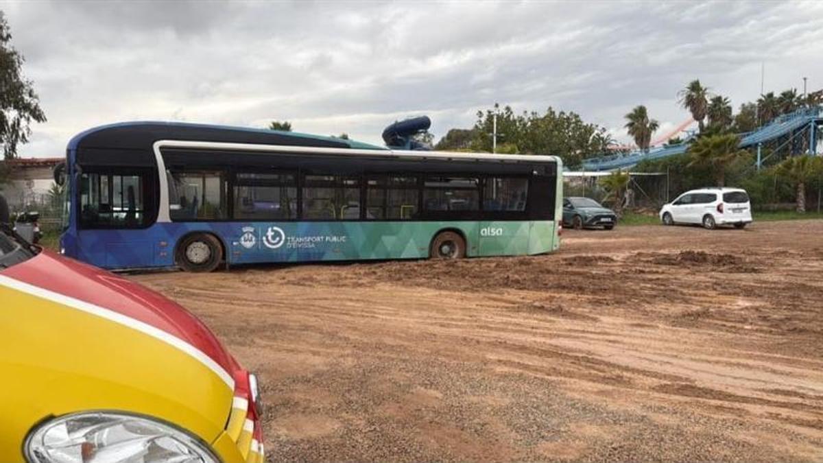 Uno de los autobuses con al menos una rueda en el fango.