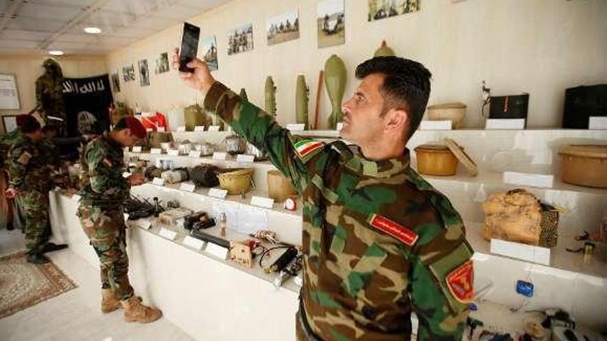 Un &quot;peshmerga&quot; kurdo se hace un selfi en un museo de Erbil (Irak) que expone material militar incautado al Estado Islámico. // Reuters