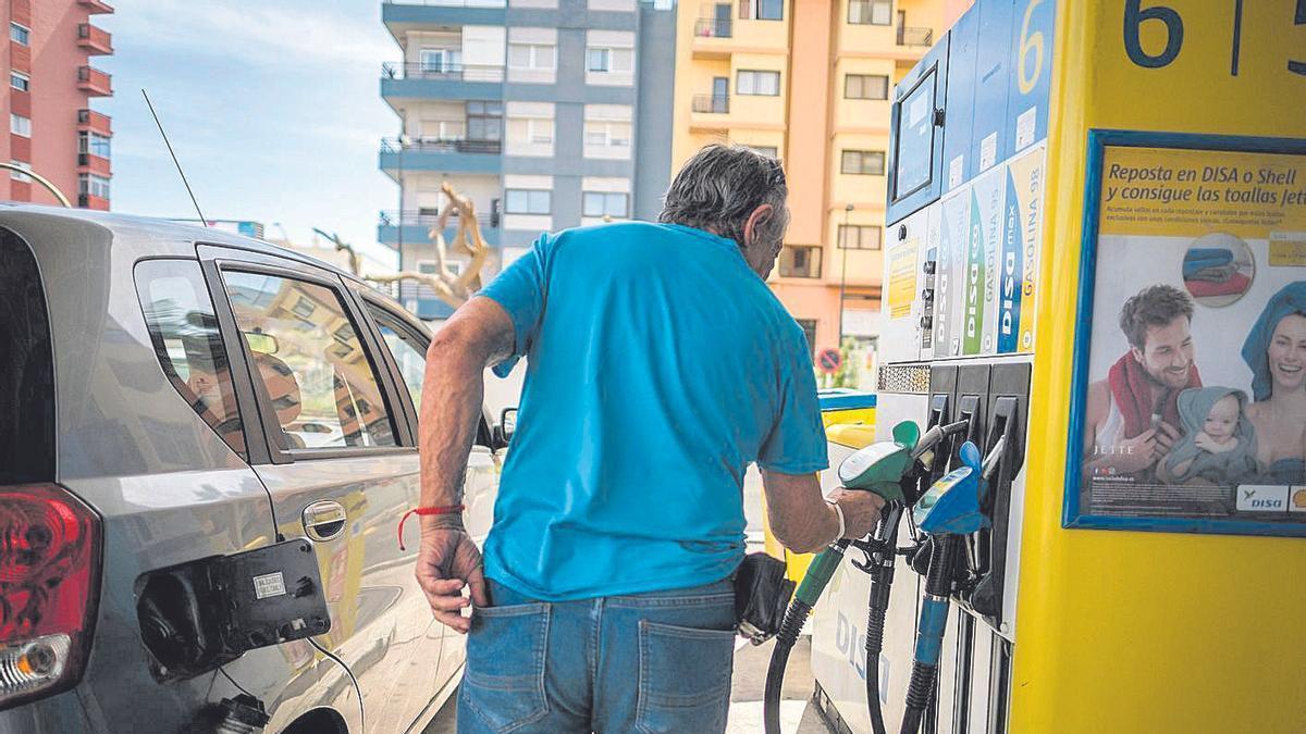 Un conductor junto a su vehículo en una estación de servicio del Archipiélago.